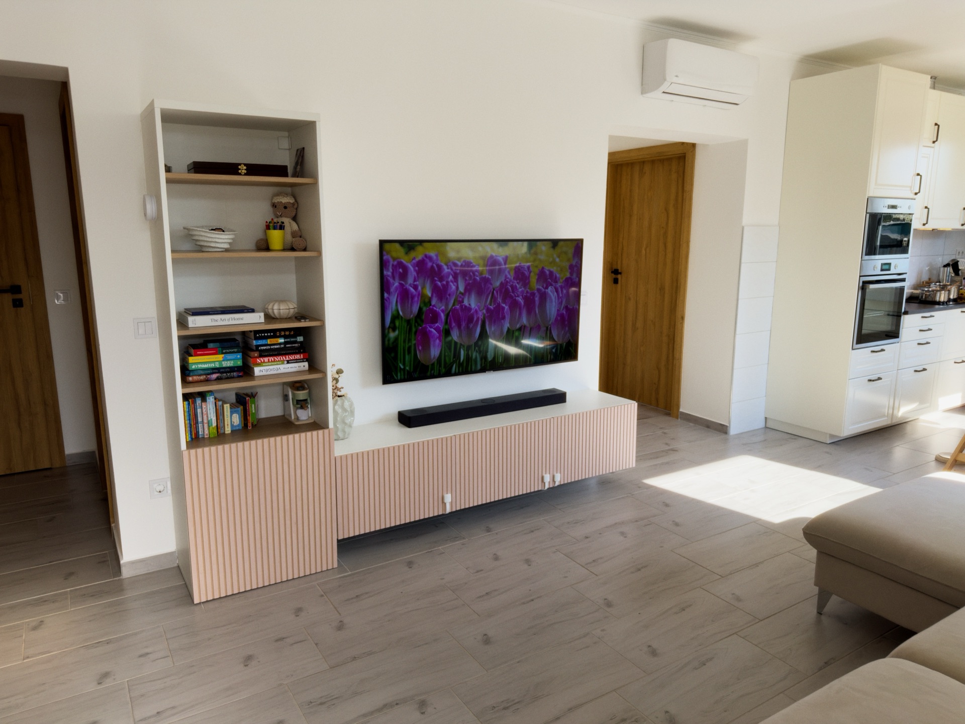 Nappali, TV-fal és bordázott rózsaszín szekrény