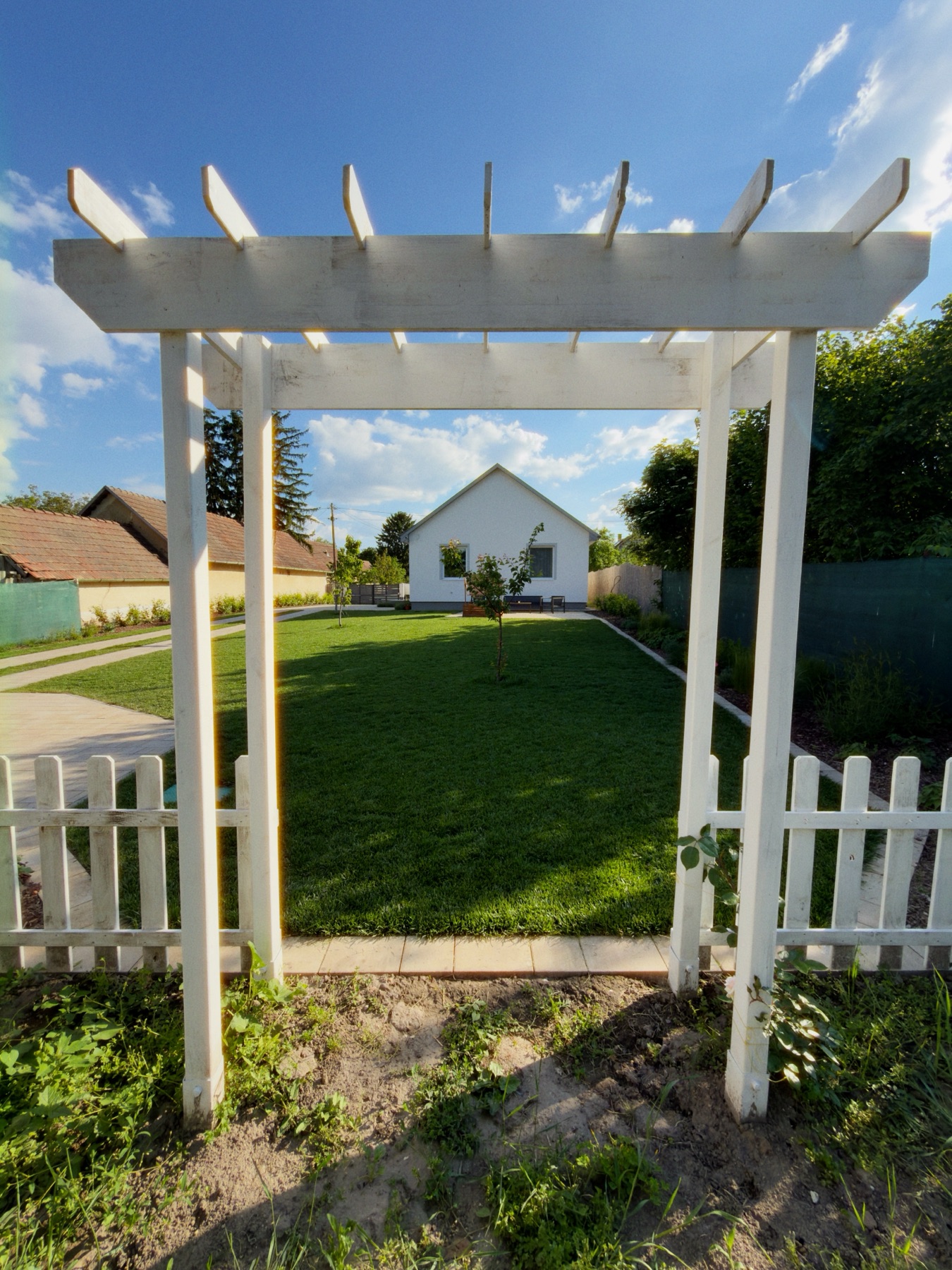 Pergola a kertben, mögötte a ház